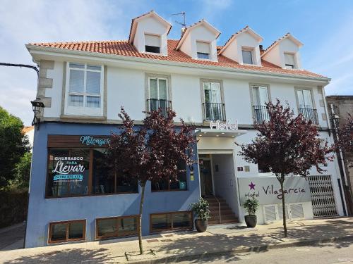 a white building with a red roof at Hotel Vilagarcia in Vilagarcia de Arousa