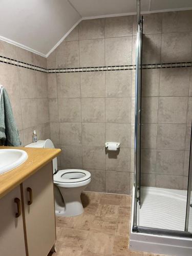 a bathroom with a toilet and a glass shower at River & Salt at Stilbaai in Stilbaai-Oos