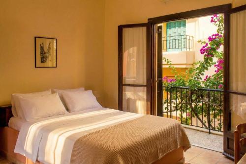a bedroom with a bed and a balcony with flowers at Iason Studios in Chania