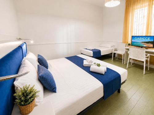 a hotel room with two beds and a tv at Appartamenti Gabicce Mare in Gabicce Mare