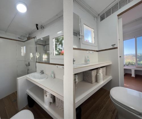 a white bathroom with two sinks and a toilet at Alojamiento Colinas in Monachil