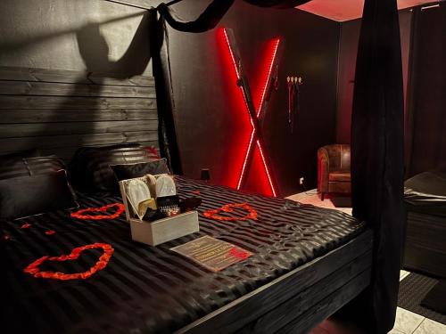 a bed in a room with a red light at La loge secrète Love Room in Dolus-le-Sec