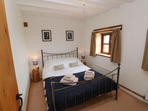 a bedroom with a bed with towels on it at Ysgol Hill Cottage in Rosebush