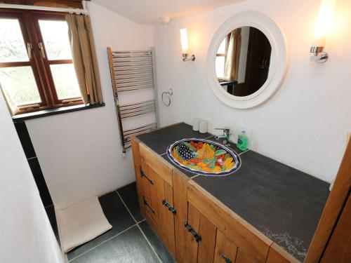 a bathroom with a sink and a mirror at Ysgol Hill Cottage in Rosebush