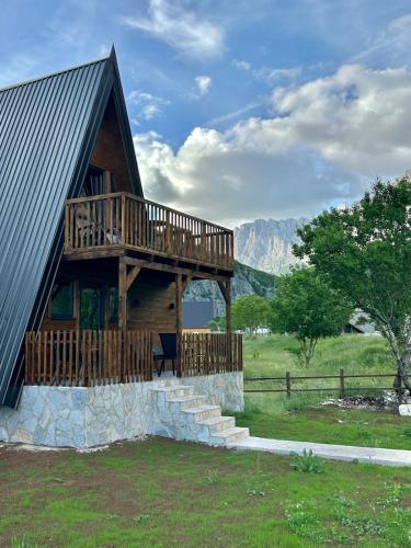 a cabin with a deck on the side of it at Komarnica Forest Owl 2 in Šavnik
