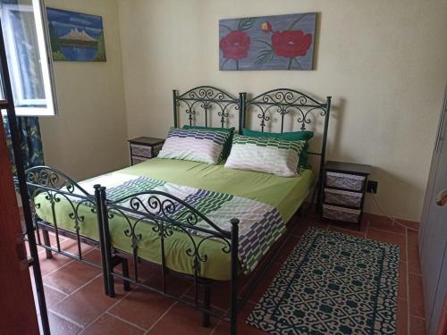 a bedroom with a bed with green sheets and pillows at Casa Maria in Matzaccara