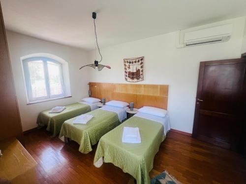 a room with two beds and a window at Holiday al Poggettone in Monteroni dʼArbia