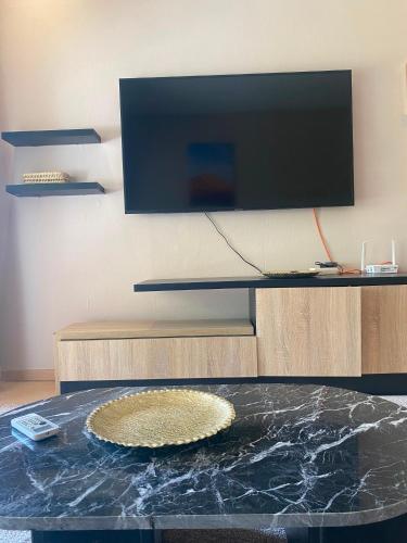 a living room with a glass table with a tv at Prestigia Marrakech in Inezgane