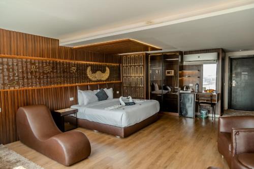 a bedroom with a bed and a couch and a chair at Hotel Comfort Giza in Cairo