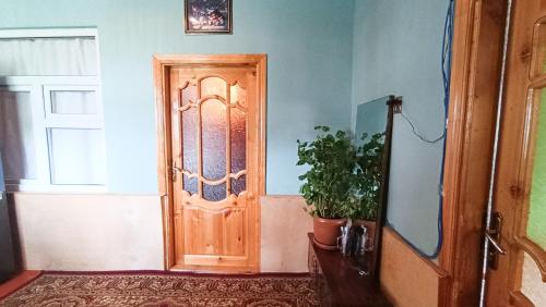 a wooden door in a room with a potted plant at Sarvan's Khinalig Riverside Montain House in Xınalıq