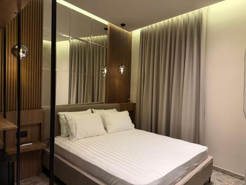 a bedroom with a bed with white sheets at The cosy inn vlora in Vlorë
