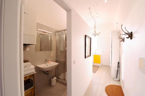 ウィーンにあるLeuhusen Boutique Apartments Vienna, Wienの洗面台と鏡のある白いバスルーム