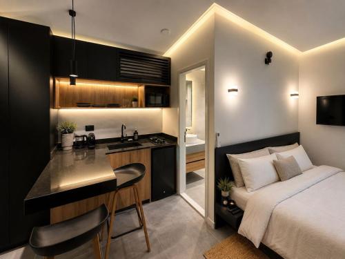 a bedroom with a bed and a kitchen with a sink at EmberHaus Retreat with Private Pool in Kafr ‘Ubaydā