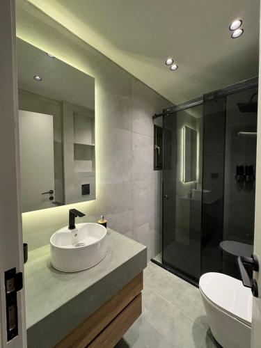 a bathroom with a sink and a shower at EmberHaus Retreat with Private Pool in Kafr ‘Ubaydā