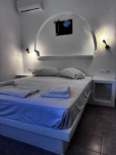 a bed in a room with two towels on it at Kapetan Sorokos Studios 2 in Koufonisia