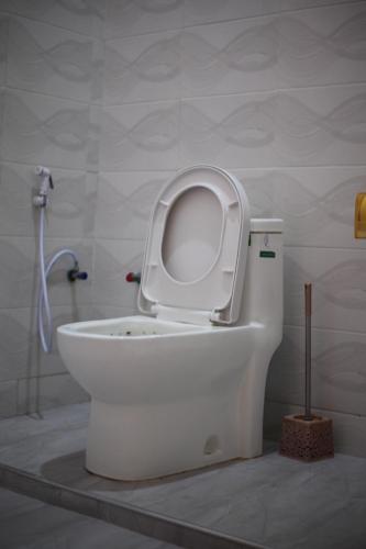 a white toilet with the seat up in a bathroom at G Villa Executive Hotel in Dodoma