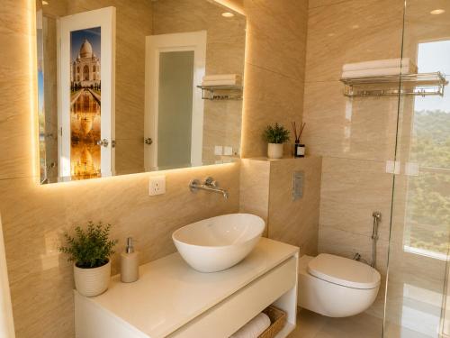 a bathroom with a sink and a toilet and a mirror at Eva & Era Paradise in Solan