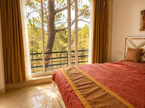 a bedroom with a bed and a large window at Eva & Era Paradise in Solan