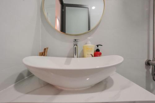 a white sink in a bathroom with a mirror at Bống's Homestay and Cafe in Ho Chi Minh City