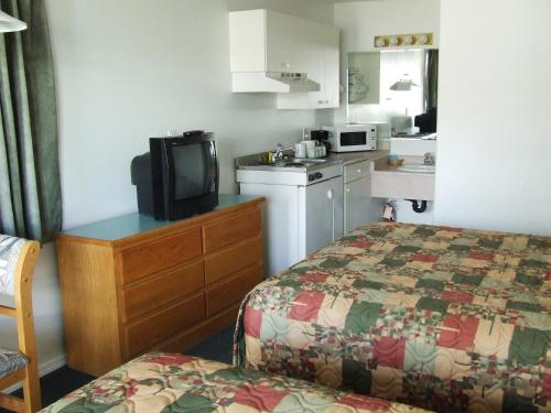 a hotel room with a bed and a small kitchen at Ponderosa Motor Inn in Golden