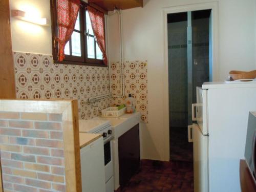 a small kitchen with a stove and a refrigerator at Gite du Fourbas in Belmont-Sainte-Foi