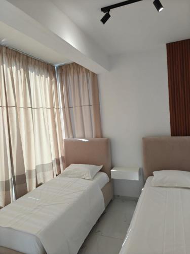 a bedroom with two beds and a window at Hotel Elisabet in Sarandë