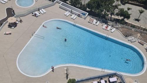 an overhead view of a large swimming pool with people in it at Paraiso Studio in Playa Paraiso
