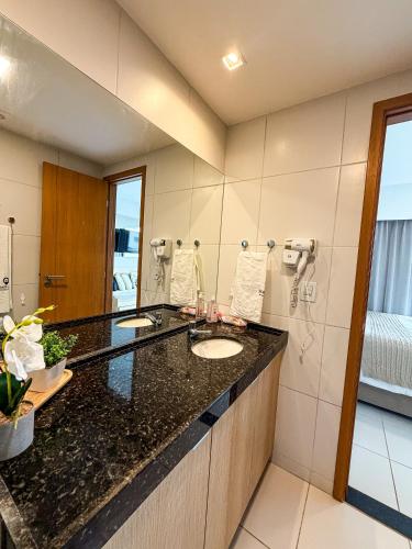 a bathroom with a sink and a mirror at Makia Beach Experience- Flat 202D in Ipojuca