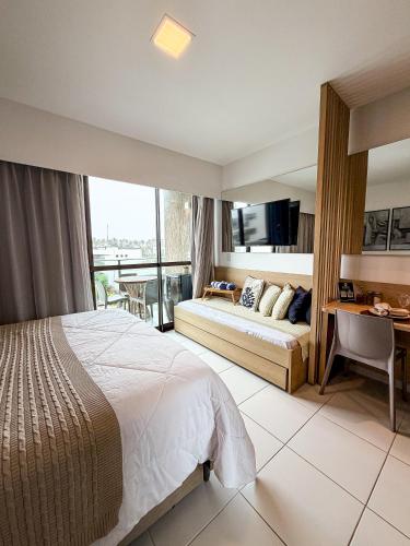 a hotel room with a bed and a desk at Makia Beach Experience- Flat 202D in Ipojuca