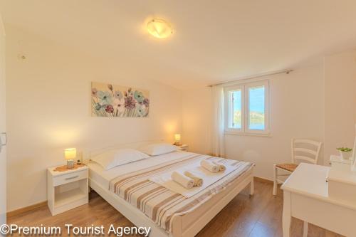 a bedroom with a bed with two towels on it at Milena Sea & Mountain View in Zubovići