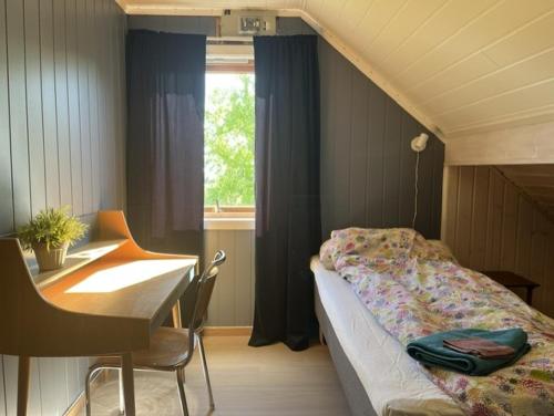 a bedroom with a bed and a desk and a window at Tenant Farm House in Dverberg