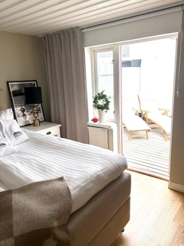 a bedroom with a large bed and a balcony at Two small houses in Ystad