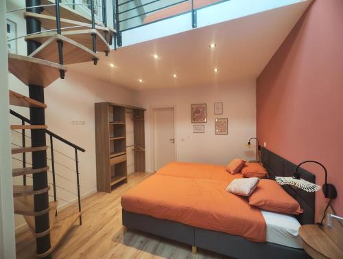 a bedroom with an orange bed and a staircase at L'atelier in Verviers