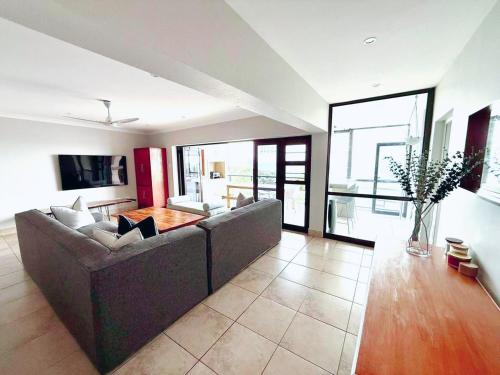 a living room with a couch and a table at 3 Bedroom - Salt Rock Beach Pad in Ballito