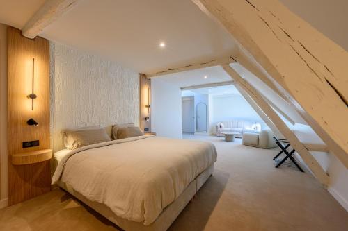 a bedroom with a large bed with an attic at Château de l'Abbatiale in Braine