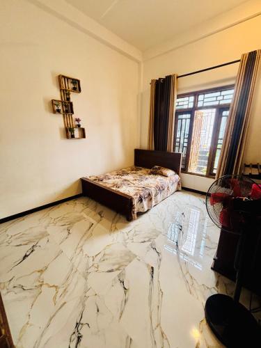 a room with a marble floor with a bed in it at Ima Manazil homestay in Kalpitiya