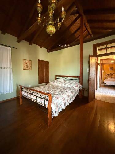 a bedroom with a bed in a room with a chandelier at Sparta Gaia Retreat in Áyios Dhimítrios