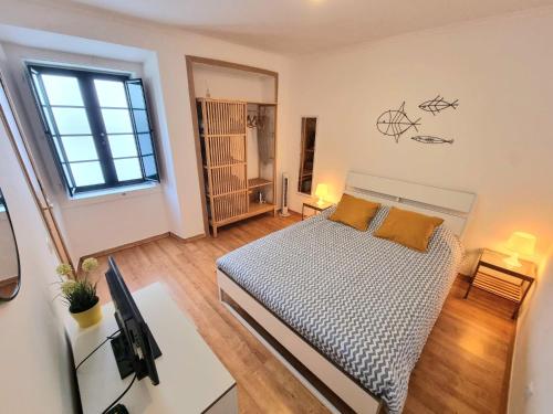 a bedroom with a bed and a desk with a television at Casa da Anunciada | Old Town in Setúbal