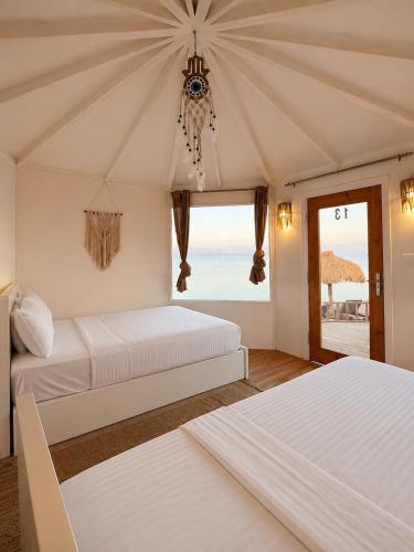 two beds in a room with a view of the ocean at Nour camp in Nuweiba