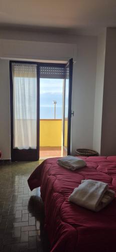 a room with two beds and a large window at Eremare Marinella in Marinella di Sarzana