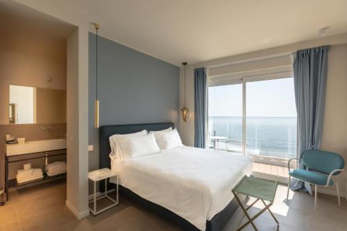 a bedroom with a bed and a large window at Acciuga Hotel in Laigueglia