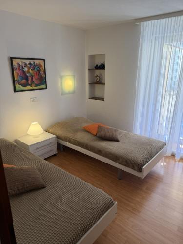 a bedroom with two beds and a window at Casa Chatelain in Ronco sopra Ascona