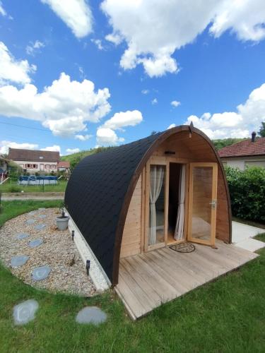 a dome tent with a wooden deck in a yard at Au petit chalet in Meisenthal