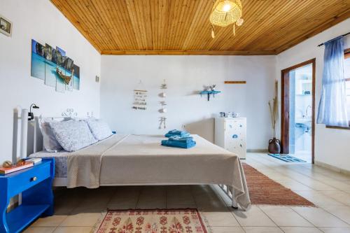 a bedroom with a bed and a wooden ceiling at Stamatis Rooms in Skopelos Town