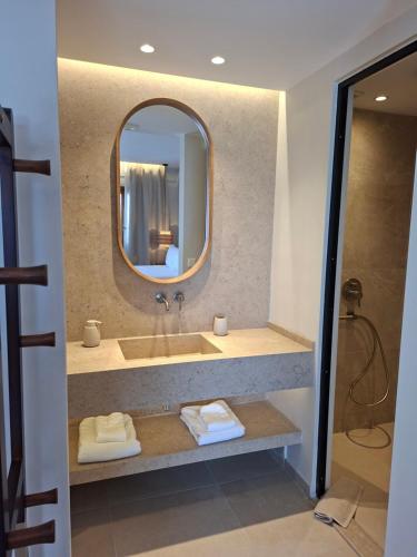 a bathroom with a sink with a mirror and towels at AVRA Apartments & Studios in Frý