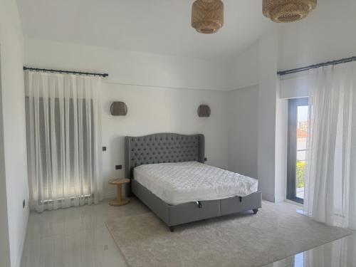 a white bedroom with a bed and a window at Luxurious Villa in Cesme with private pool in Çeşme