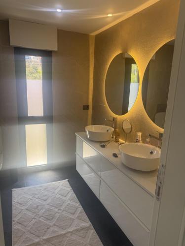 a bathroom with two sinks and two mirrors at Luxurious Villa in Cesme with private pool in Çeşme