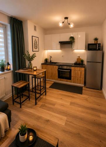 a living room with a kitchen and a table at Classic Apartment in Konin