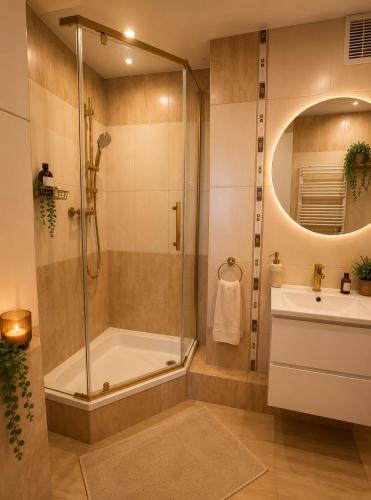 a bathroom with a shower and a tub and a sink at Classic Apartment in Konin
