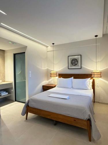 a bedroom with a large bed with two lamps at AVRA Apartments & Studios in Frý